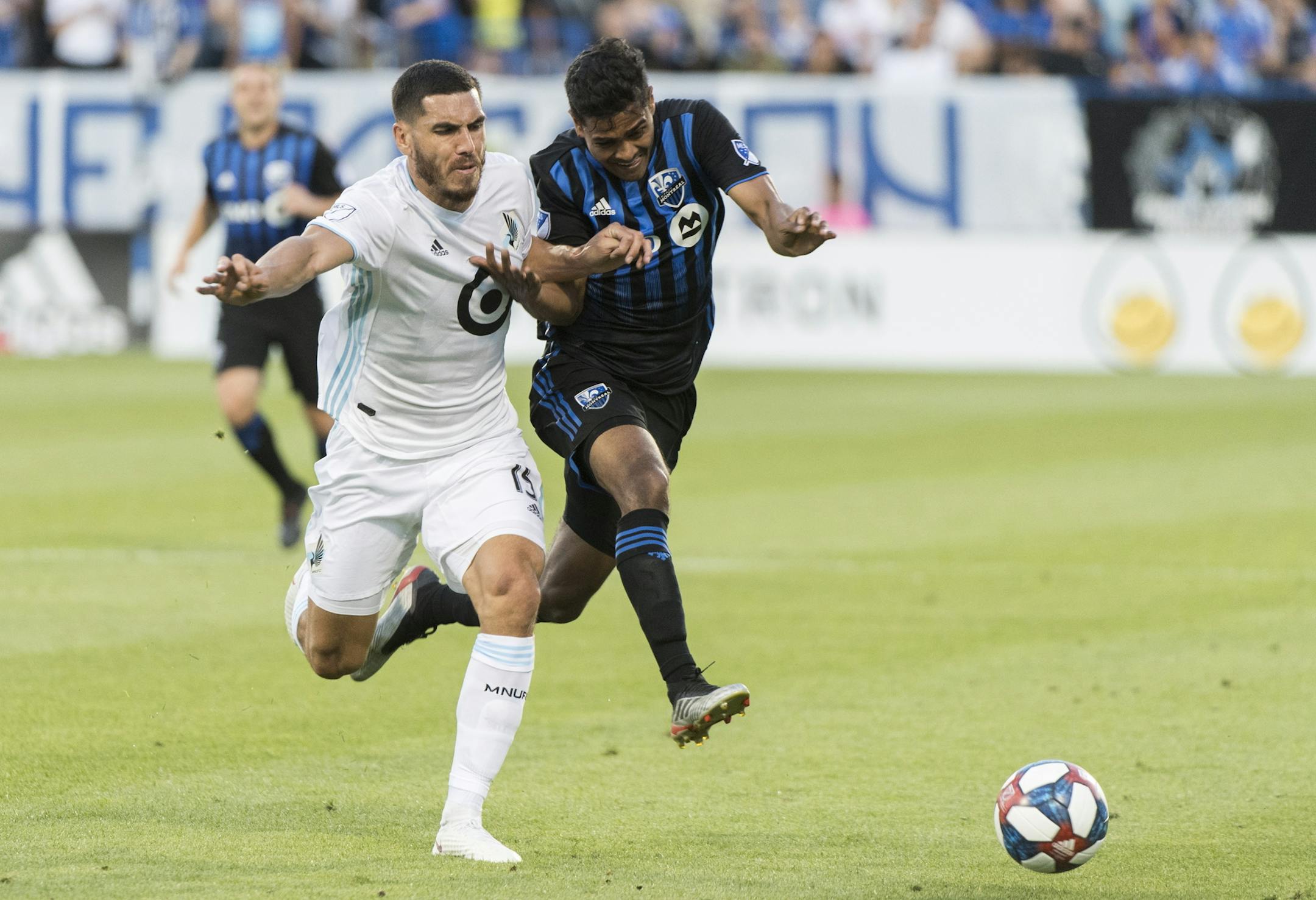 Montreal Impact's Shamit Shome, right, and Minnesota United's Michael Boxall race to the ball during the first half of an MLS soccer match Saturday, July 6, 2019, in Montreal. (Graham Hughes/The Canadian Press via AP)