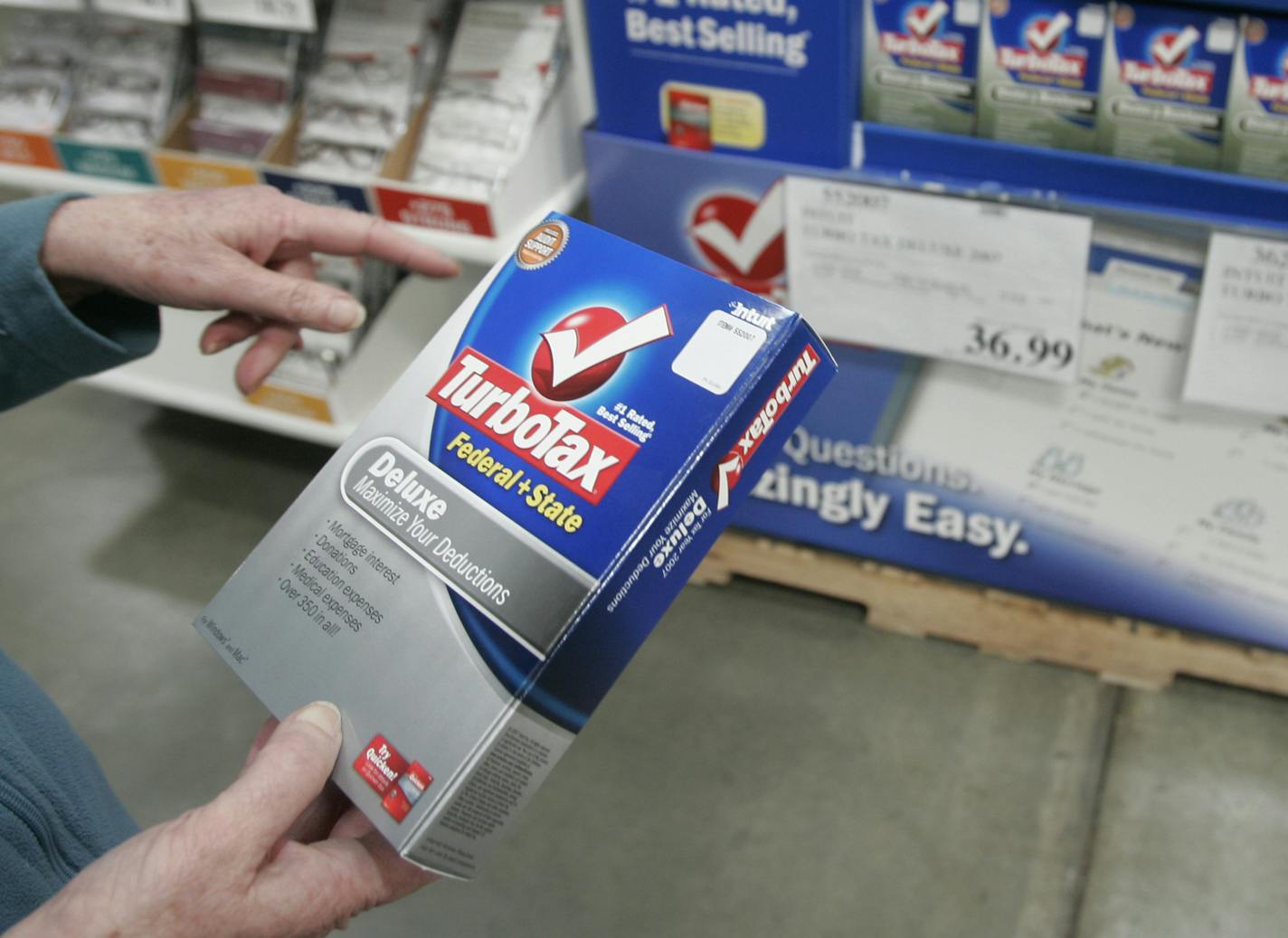 FILE - In this Wednesday, March 5, 2008, file photo. a Costco shopper purchases TurboTax at Costco in Mountain View, Calif. According to a three-month AP investigation released in January 2013, five years after the start of the Great Recession, instead of relying on someone else in the workplace or their personal lives, people are using technology to do tasks independently. (AP Photo/Paul Sakuma, File) ORG XMIT: MIN2013030816342343
