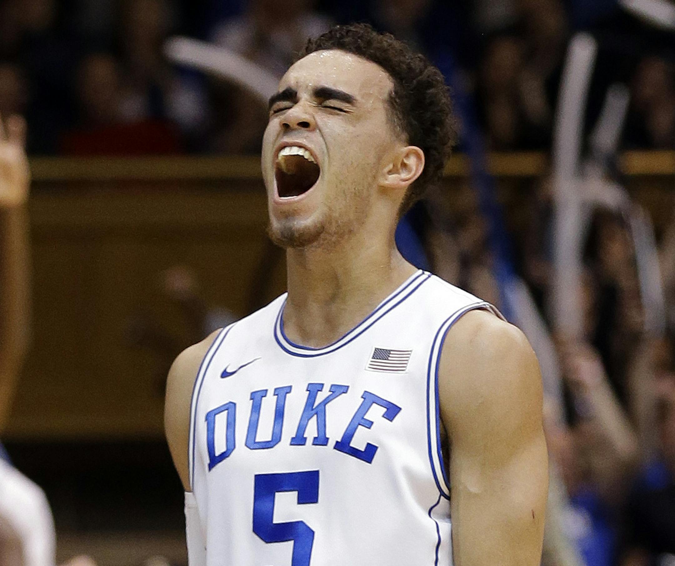 Duke's Tyus Jones (5) and Amile Jefferson (21), rear, react following Jones' basket against Notre Dame during the first half of an NCAA college basketball game in Durham, N.C., Saturday, Feb. 7, 2015. Duke won 90-60. (AP Photo/Gerry Broome)