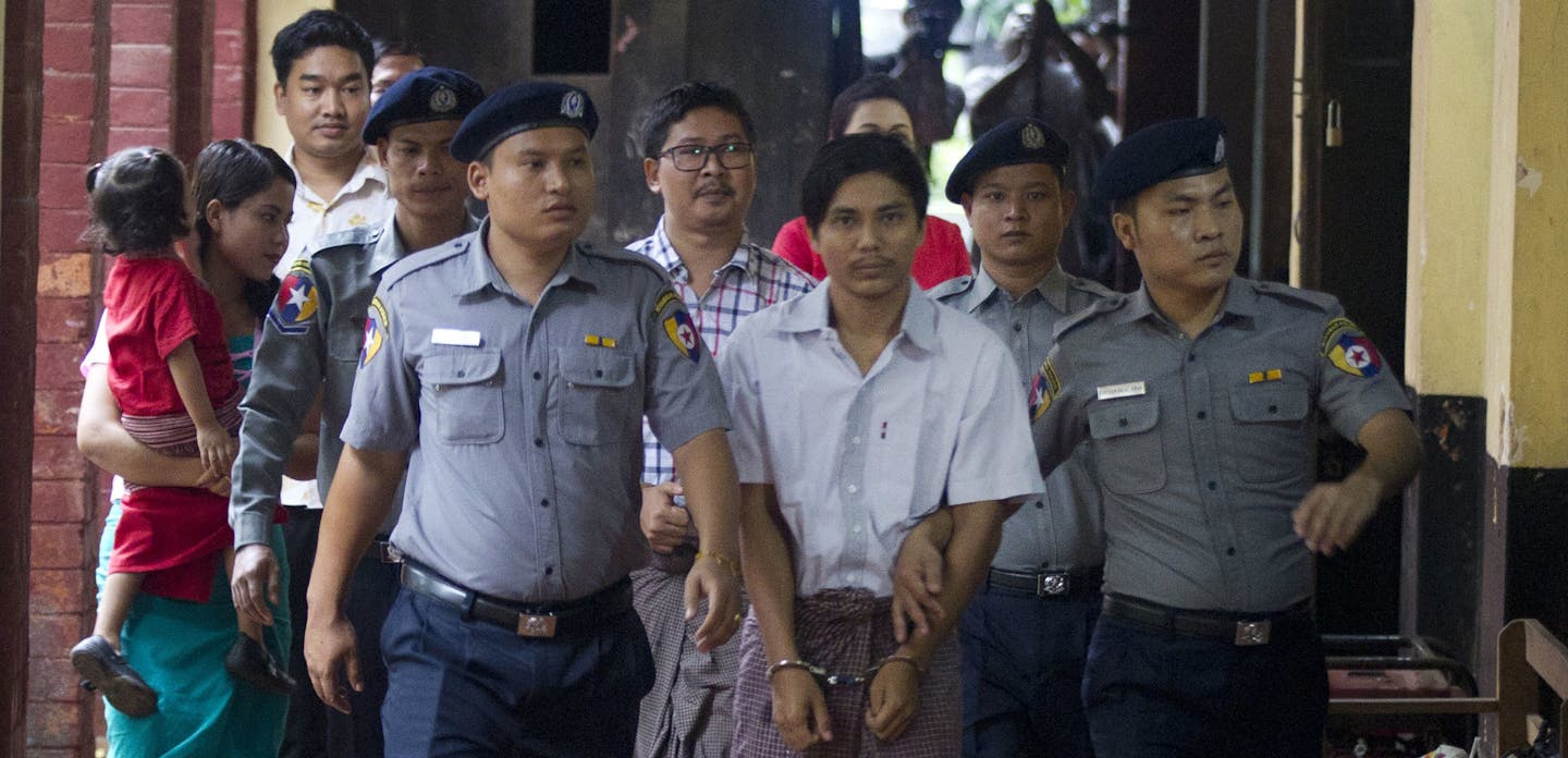 Two Reuters journalists Kyaw Soe Oo, center front, and Wa Lone, center back, are escorted by polices upon arrival at their trial Monday, Aug. 20, 2018, in Yangon, Myanmar. The two reporters, Wa Lone and Kyaw Soe Oo are accused of illegally possessing official information. (AP Photo/Thein Zaw)