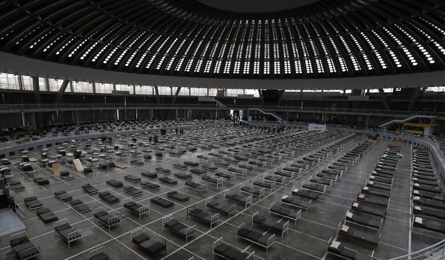 Serbian soldiers set up beds for treatment of possible COVID-19 infected patients inside of the Belgrade Fair, Serbia, Tuesday, March 24, 2020. For most people, the new coronavirus causes only mild or moderate symptoms. For some it can cause more severe illness. (AP Photo/Darko Vojinovic) ORG XMIT: XDMV110