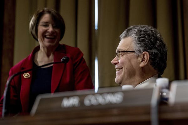Senate Judiciary Committee members, Sen. Al Franken, D-Minn., right, and Sen. Amy Klobuchar, D-Minn. speak on Capitol Hill in Washington, Tuesday, Jan