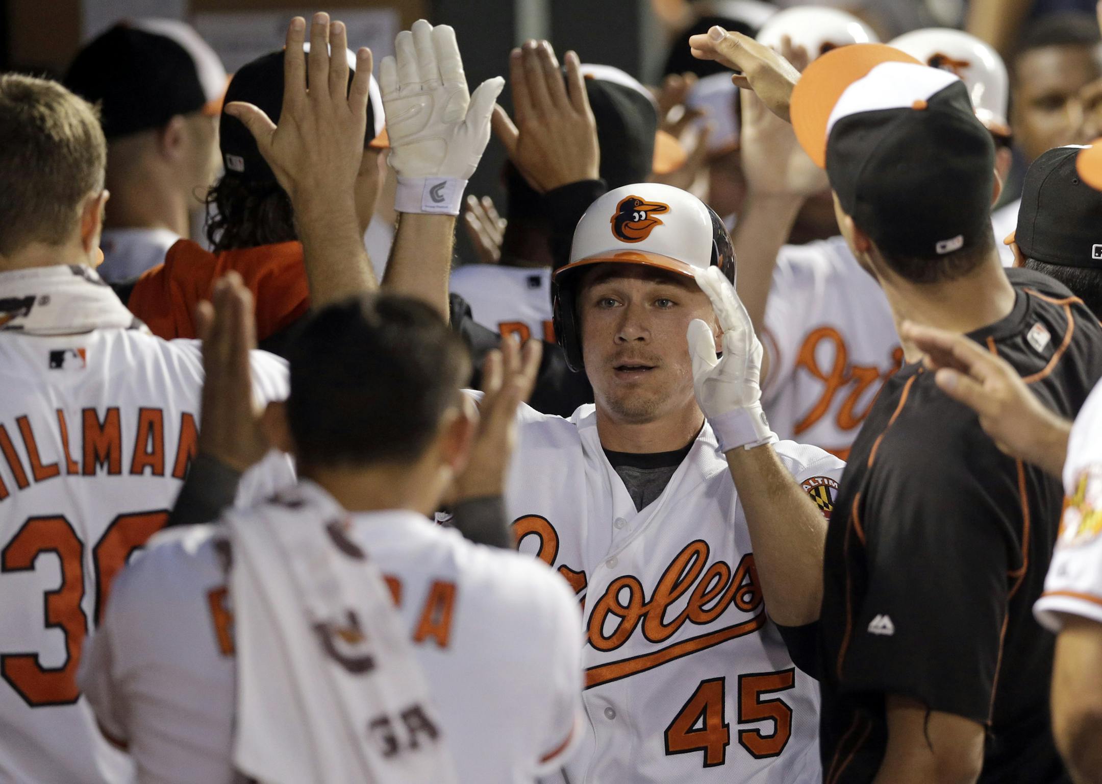Baltimore Orioles' Steve Clevenger (45) high-fives teammates in the dugout after hitting a three-run home run in the fourth inning of a baseball game against the Oakland Athletics, Monday, Aug. 17, 2015, in Baltimore. Baltimore won 4-2. (AP Photo/Patrick Semansky)