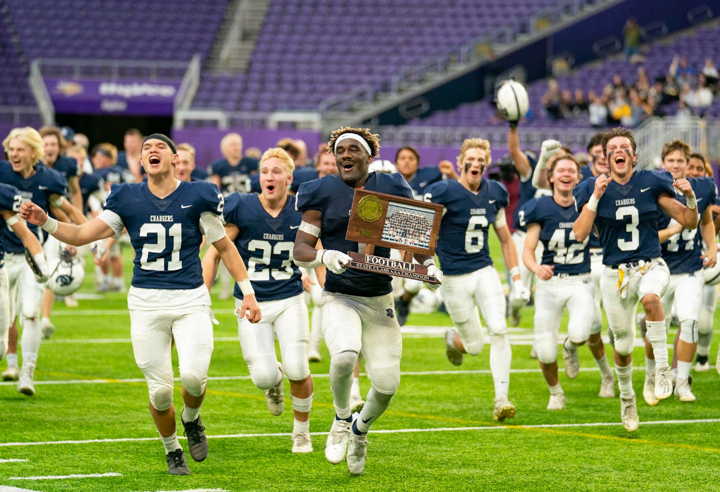 Dassel-Cokato High School players run toward the student section to celebrate with their classmates after defeating Plainview-Elgin-Millville High School 28-21 in the Minnesota High School football Class 3A State Championship Saturday, Nov. 27, 2021 at U.S. Bank Stadium in Minneapolis. ]