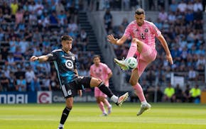 Inter Miami midfielder Sergio Busquets possesses the ball in front of Minnesota United midfielder Joaquín Pereyra in the first half at Allianz Field