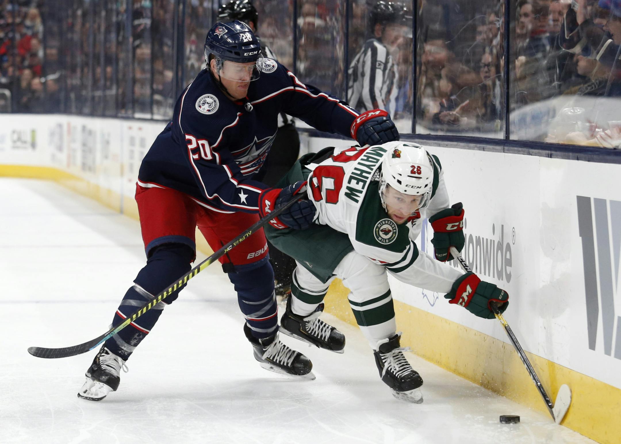 Columbus Blue Jackets forward Riley Nash, left, checks Minnesota Wild forward Gerald Mayhew during the first period of an NHL hockey game in Columbus, Ohio, Friday, Feb. 28, 2020. (AP Photo/Paul Vernon)