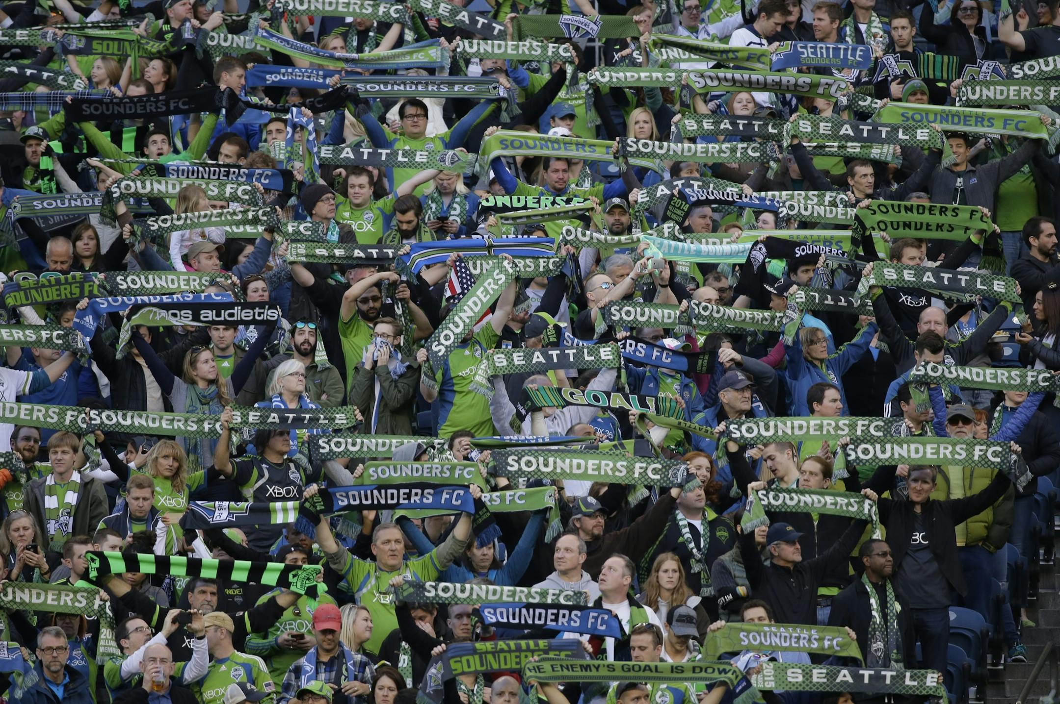 Seattle Sounders supporters in a crowd of nearly 40,000 hold up scarves at the start of an an MLS soccer match against the New England Revolution, Sunday, March 8, 2015, in Seattle. (AP Photo/Ted S. Warren) ORG XMIT: OTK