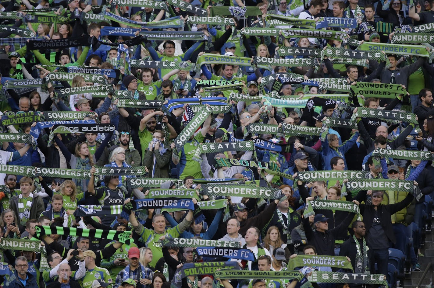 Seattle Sounders supporters in a crowd of nearly 40,000 hold up scarves at the start of an an MLS soccer match against the New England Revolution, Sunday, March 8, 2015, in Seattle. (AP Photo/Ted S. Warren) ORG XMIT: OTK