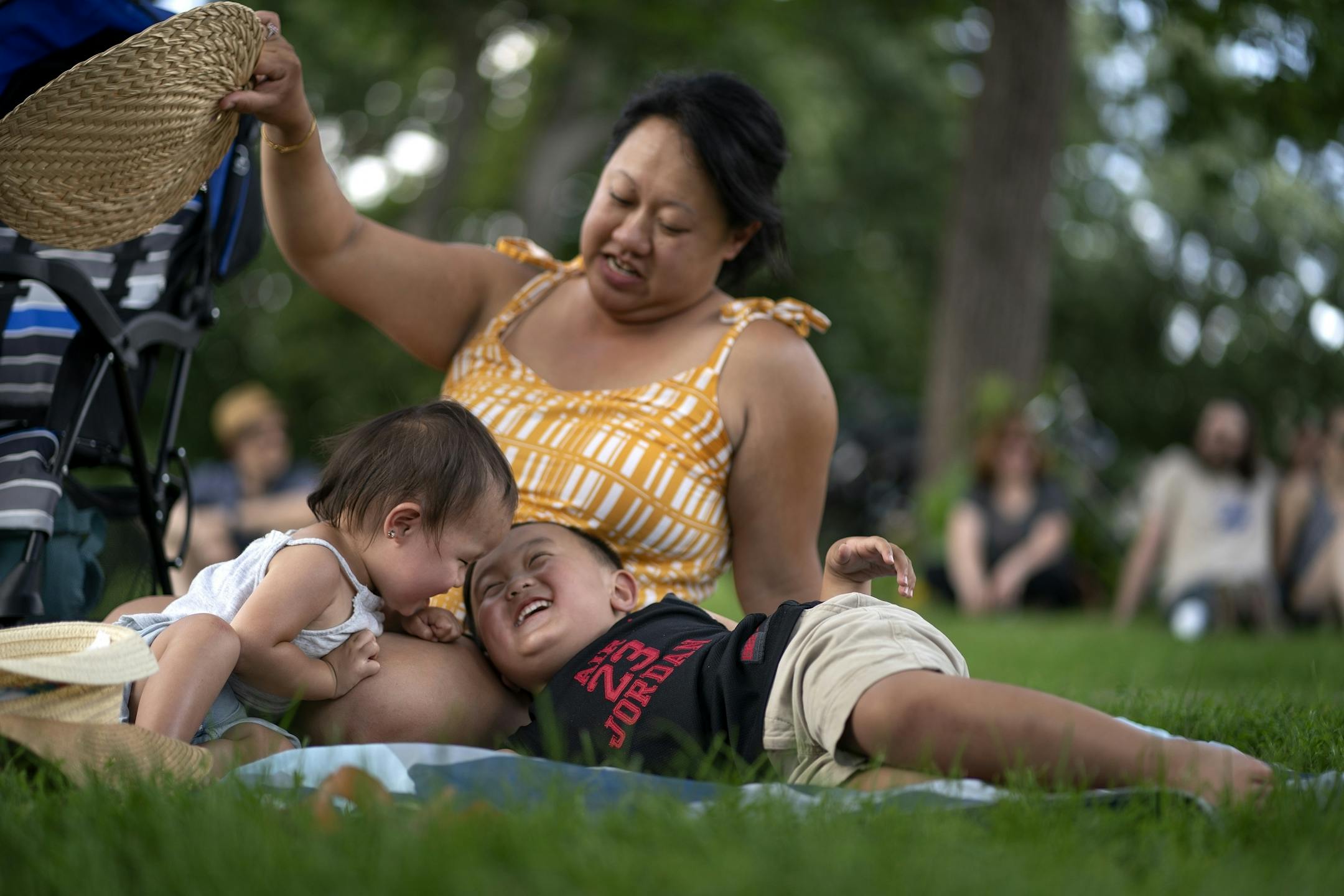 Gold Lor fans her kids Harlow Thao 1 1/2 , and Jaxon Thao 4 during Twin Cities World Refugee Day in Loring Park Sunday July,14 2019 in Minneapolis, MN.