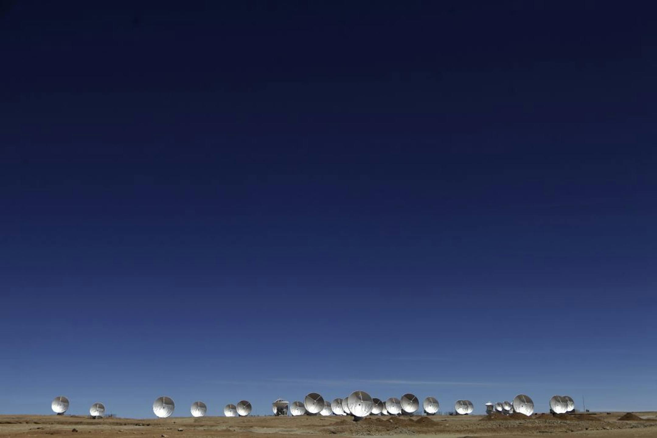 In this Sept. 27, 2012 photo, radio antennas face the sky as part of one of the worlds largest astronomy projects, the Atacama Large Millimeter/submillimeter Array (ALMA) in Chajnator in the Atacama desert in northern Chile. Linked as a single giant telescope, the radio antennas pick up wavelengths of light longer than anything visible to the human eye and colder than infrared telescopes, which are good at capturing images of distant suns but miss planets and clouds of gases from which stars are