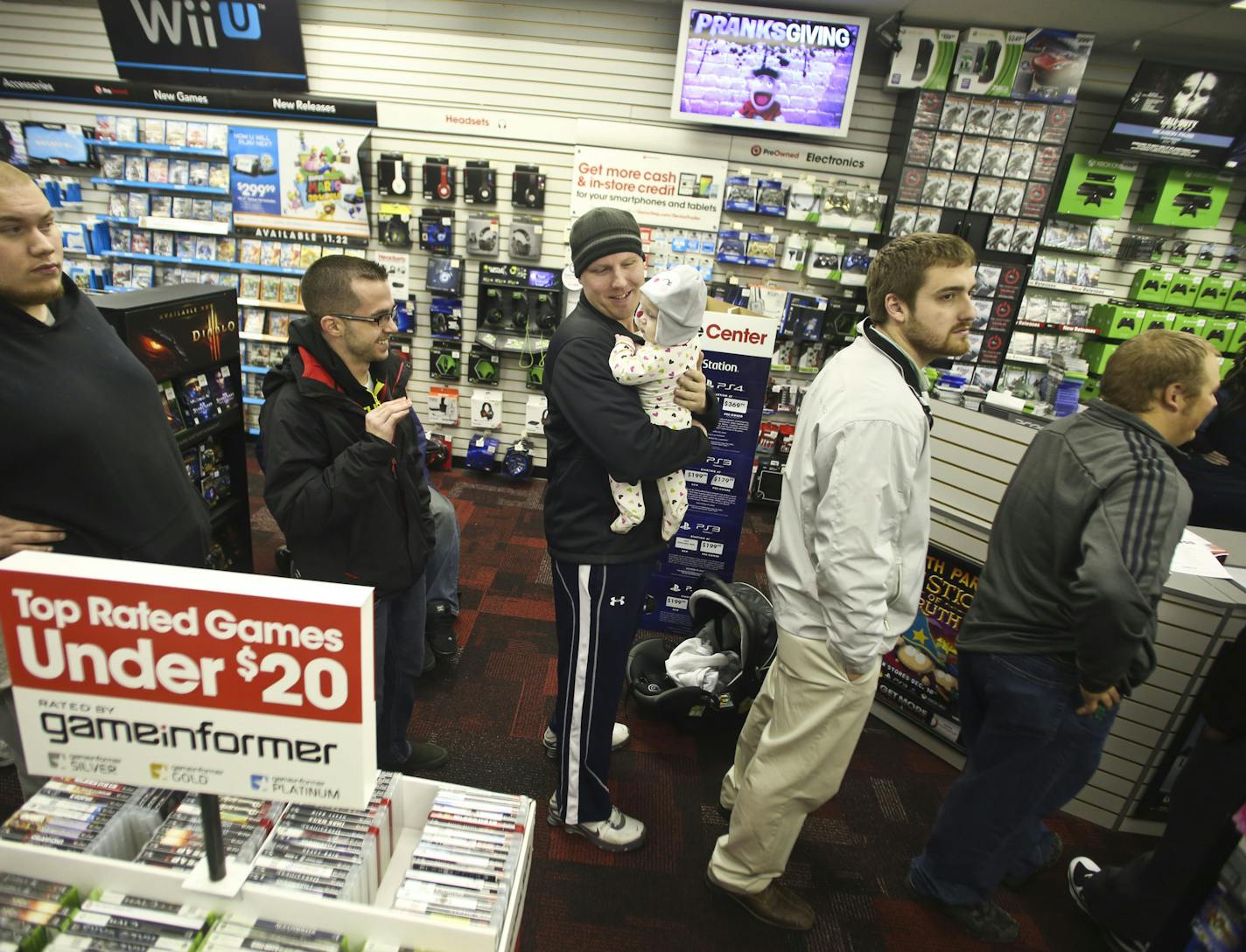 James Silda stood in a line of about 20 people with his eight-month old daughter Quinn as he waited in to get a ticket to purchase the new Xbox One later on that night at midnight at Gamestop on Thursday, November 21, 2013 in Roseville, Minn. ] RENEE JONES SCHNEIDER &#x2022; reneejones@startribune.com