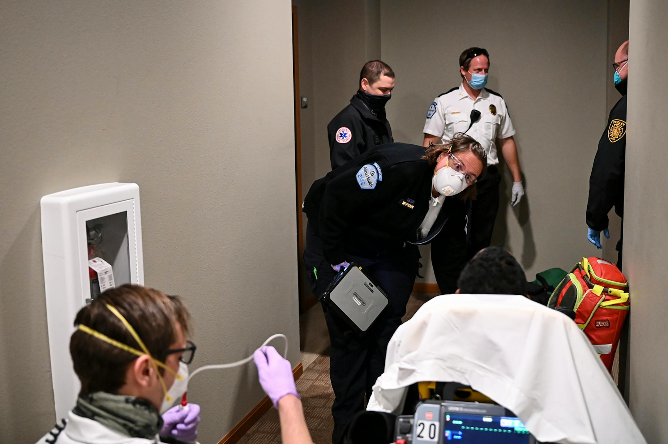 Allina Health Paramedic Crystal Gaughan leaned down to speak to a 12-year old patient, suspected of having COVID-19, before transporting them to a local hospital Wednesday. ] AARON LAVINSKY • aaron.lavinsky@startribune.com Emergency medical workers and physician Andrew Stevens responded to possible COVID-19 related calls on Wednesday, Dec. 2, 2020 in the north Twin Cities metro.