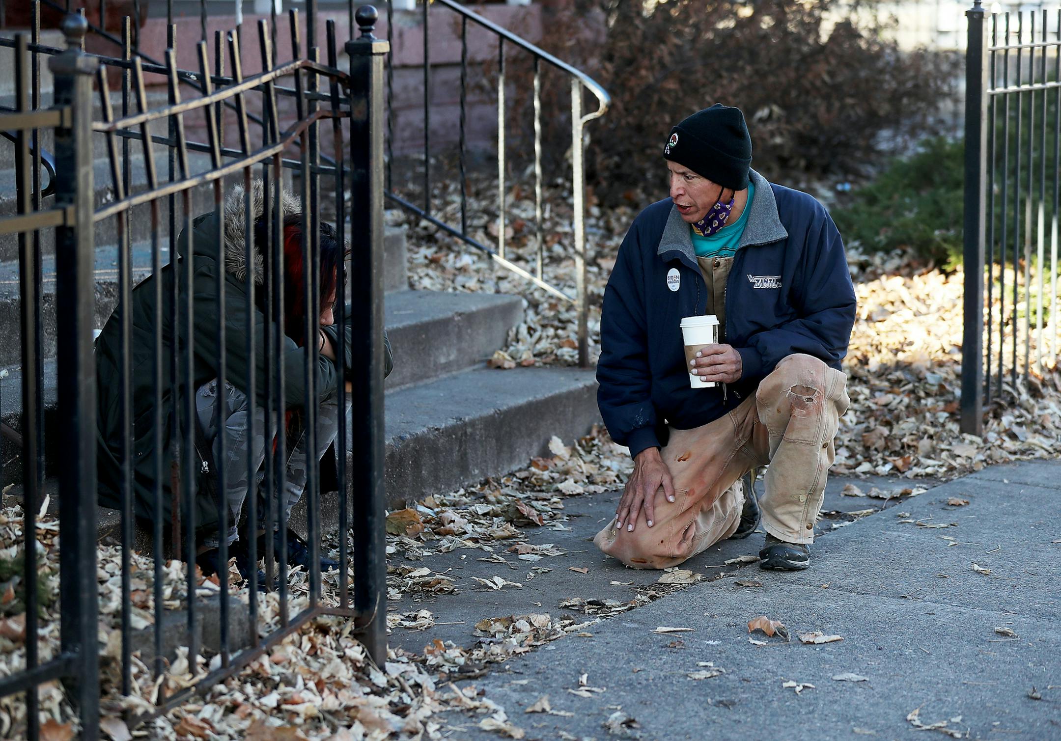 Allen Touche, 48, kneels down to comfort a woman who had been slumped over, her head in her lap, as Touche passed on his  weekly Saturday journey to help feed homeless Natives and others in Minneapolis. Touche, who told the woman he has battled hard times and later brought her a plate of food, this past summer slept in a tent on a site in Minneapolis know as the Wall of Forgetten Natives.  While still homeless, Touche succeeded in getting a union job working construction on an apartment complex across from the Wall called Mino-bimaadiziwin, in Ojibwe for "the good life" —a low-rent complex targeted specifically to Native Americans and Touche will move in to his own place there come the beginning of 2020. "I put my blood, sweat and tears into this place," he said during a recent visit to the complex.  "My own physical labor built this building." ]