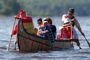 In this Star Tribune file photo, visitors to Voyageurs National Park ride in a 26-foot replica of a voyageurs canoe on Rainy Lake. Costumed interprete