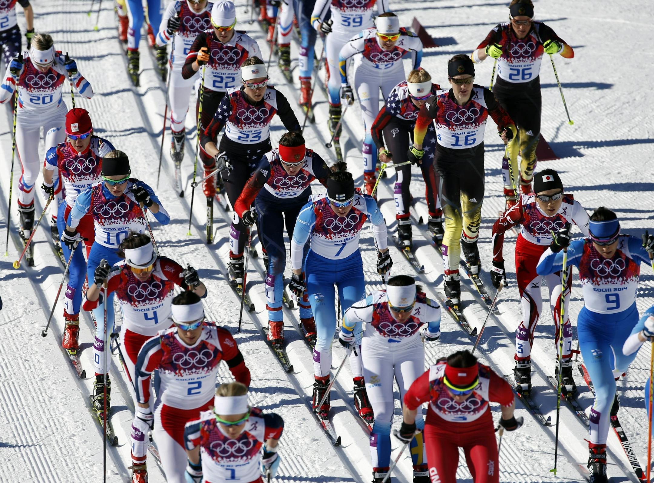 Competitors ski during the women's cross-country 15k skiathlon at the 2014 Winter Olympics, Saturday, Feb. 8, 2014, in Krasnaya Polyana, Russia.