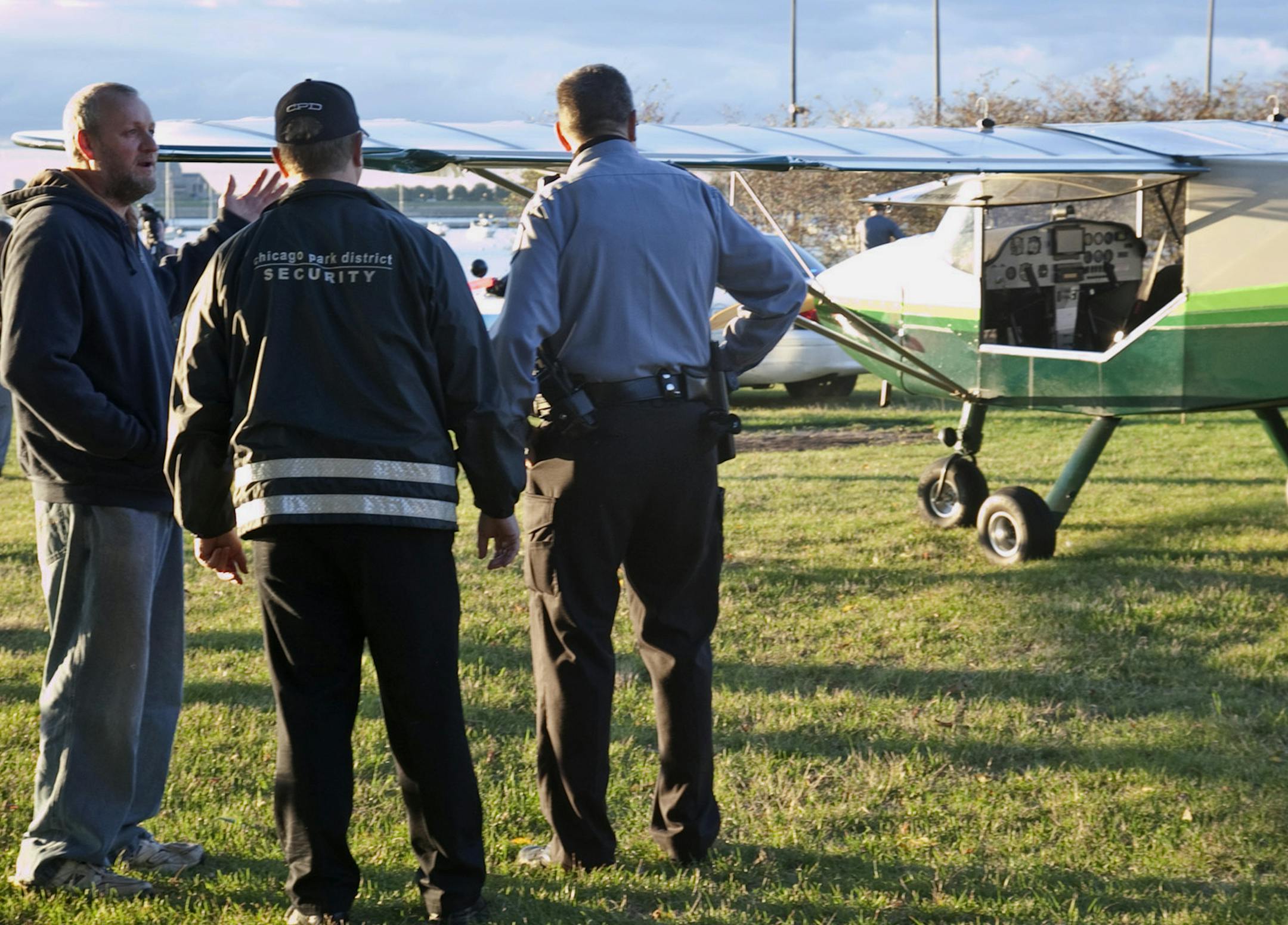 Pilot John Pederson, left, 51, landed his single-engine plane near Lake Shore Drive in Chicago early Sunday, Sept. 22, 2013 in an emergency landing because of mechanical issues. He landed in the northbound lanes of Lake Shore Drive near Grant Park, authorities said. Chicago police said no one was injured. (AP Photo/Sun-Times Media, Ashley Rezin) MANDATORY CREDIT SUN-TIMES MEDIA; MAGS OUT