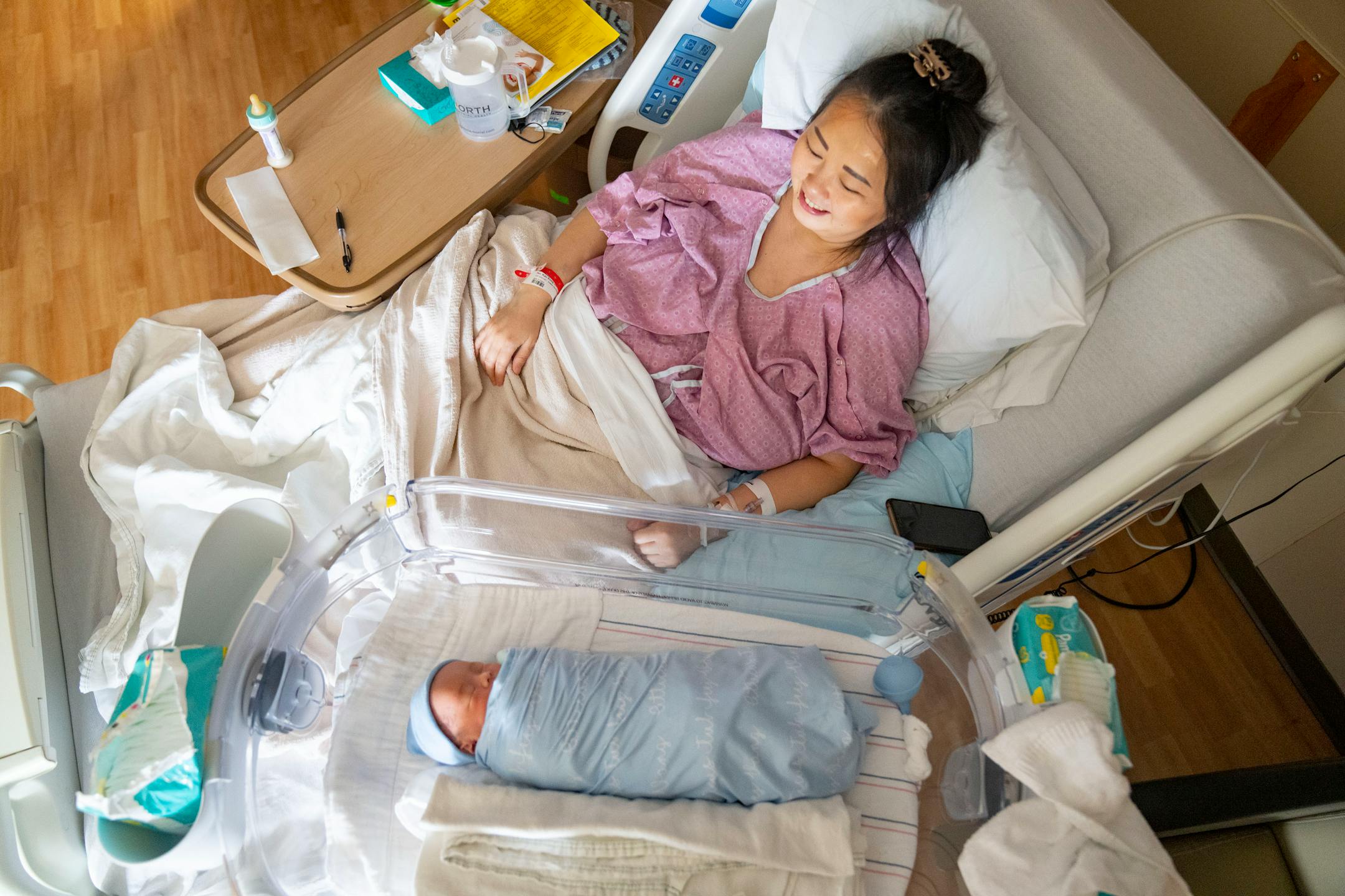 Kao Her rests beside her newborn son, Atticus Vang, Thursday, March 24, 2022 at Maple Grove Hospital in Maple Grove, Minn
