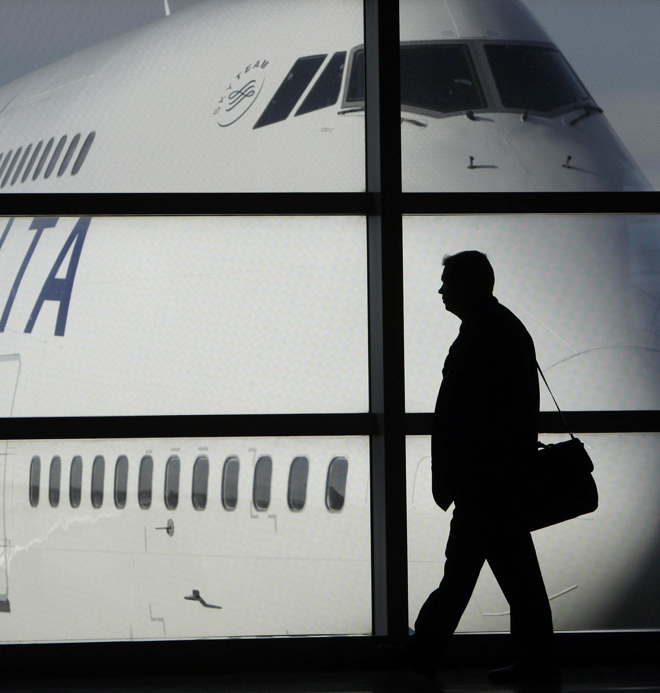 FILE - In this Jan. 21, 2010 file photo, a passenger walks past a Delta Airlines 747 aircraft in McNamara Terminal at Detroit Metropolitan Wayne County Airport in Romulus, Mich. Fares are higher, demand is up and the airlines have established a steady revenue stream from add-on fees for baggage, pillows and food. (AP Photo/Paul Sancya, file) ORG XMIT: MIN2012090615575792