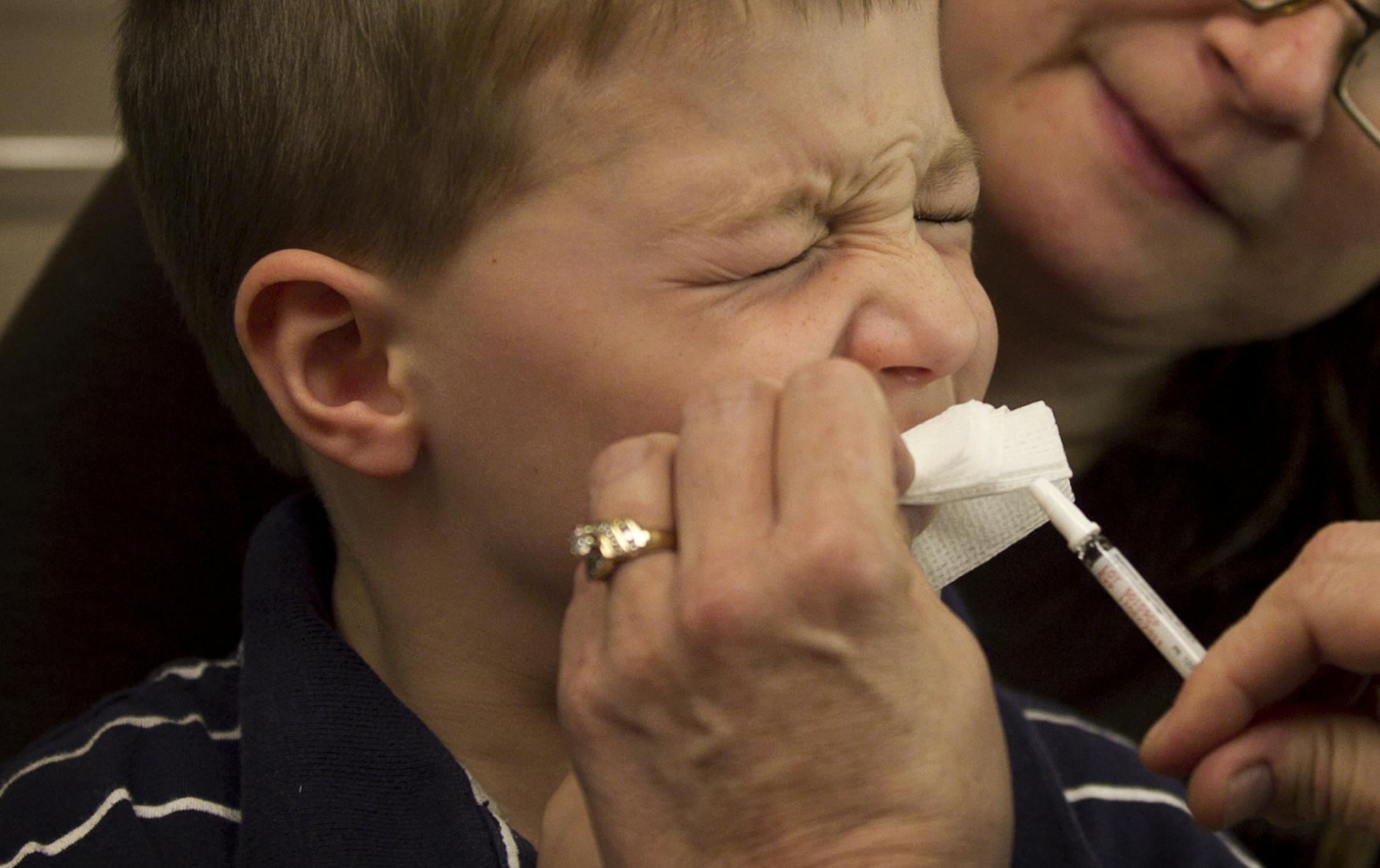 With his mom Lori Wiggenhorn at his side ,Ben Wiggenhorn was given a flu mist vaccine by Health Partners LPN Michele Zubert at the clinic in Arden Hills, MN.] (Jerry Holt/ STAR TRIBUNE/jgholt@startribune.com) Wiggenhorn (cq)