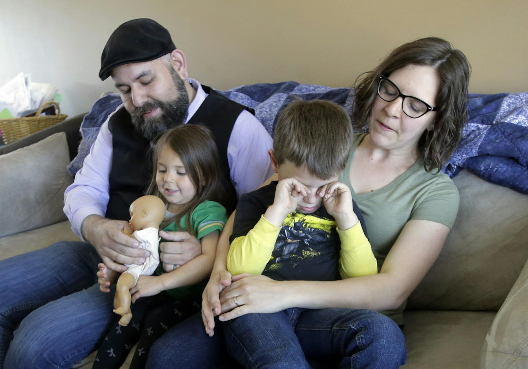 Jake Martinez, 32, holds his daughter Jenny, 3, while his wife Kat, 31, holds their son Joe, 5, at their home Thursday, May 4, 2017, in Murray, Utah. Jake Martinez, who has epilepsy, is worried about health insurance as Republicans move closer to dismantling the Obama health care system, known as the Affordable Care Act, which he and his wife use. (AP Photo/Rick Bowmer)