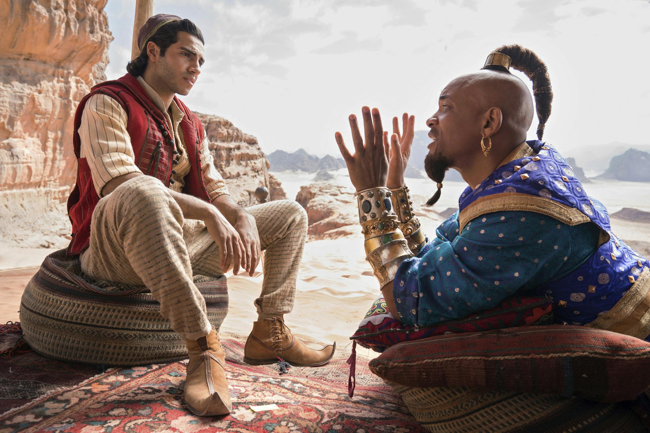 This image released by Disney shows Mena Massoud as Aladdin, left, and Will Smith as Genie in Disney's live-action adaptation of the 1992 animated classic "Aladdin." (Daniel Smith/Disney via AP)