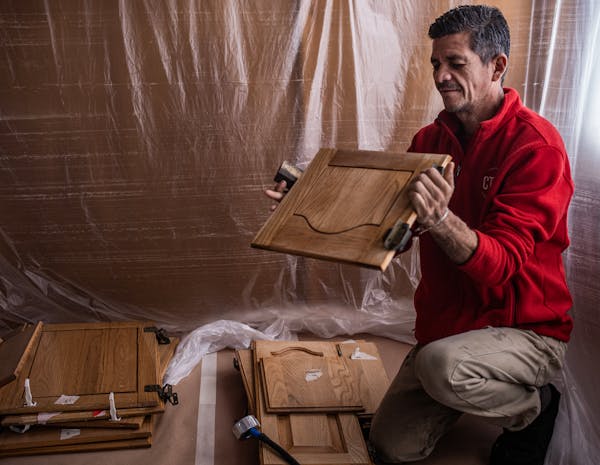 Roberto Jacobo, an advocate for workers’ rights and home remodeler, is sanding kitchen cabinets on his porch in Apple Valley.