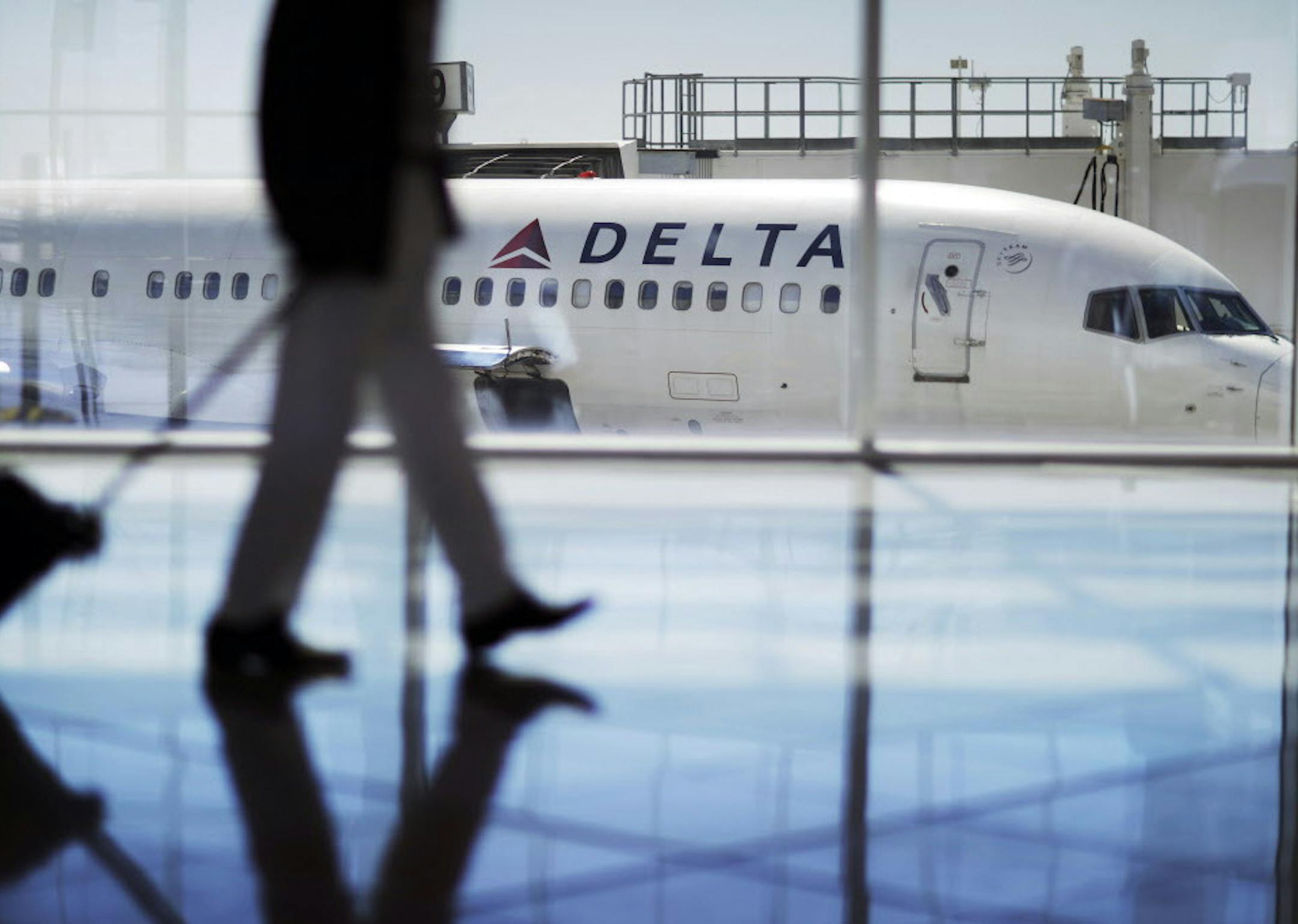 FILE - In this Oct. 13, 2016 file photo, a Delta Air Lines jet sits at a gate at Hartsfield-Jackson Atlanta International Airport in Atlanta. Delta Air Lines says it has canceled about 3,000 flights this week as it continues to struggle in the aftermath of a storm that hit its hub airport in Atlanta. The thunder storm hit Wednesday, April 5, 2017, but canceled flights and long lines in Atlanta persisted into Friday. Tracking service FlightAware.com says Delta had canceled more than 400 flights b