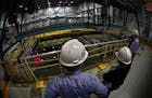 Xcel Energy employees examine a 38-foot-deep pool that holds spent fuel rods at its Monticello Nuclear Generating Plant. The utility said Monday it wi