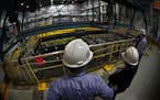 Xcel Energy employees examine a 38-foot-deep pool that holds spent fuel rods at its Monticello Nuclear Generating Plant. The utility said Monday it wi