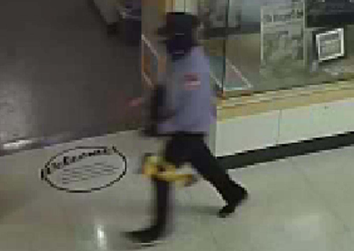 This surveillance image released by police shows the suspect walking away with awards given to Roger Maris.