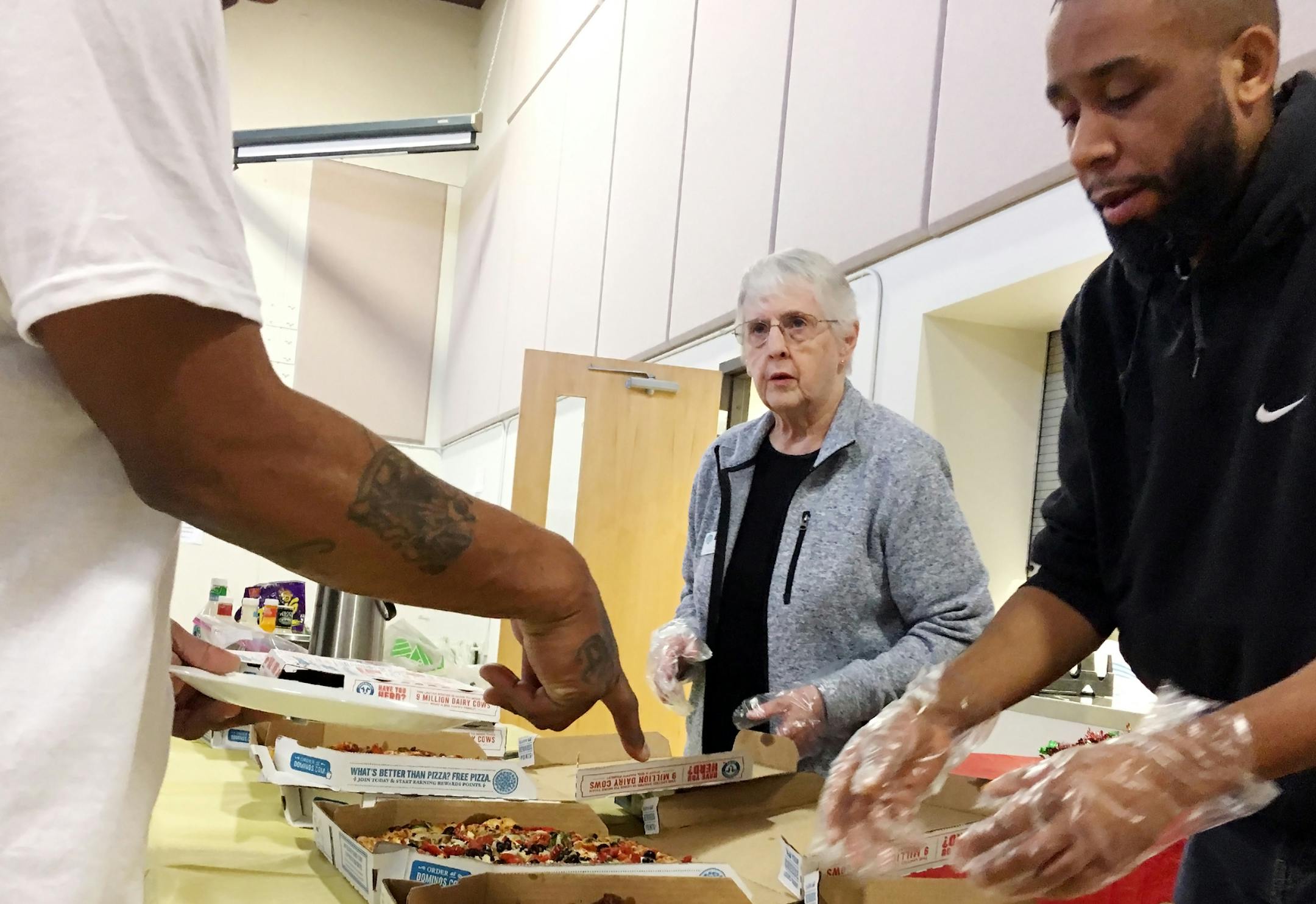 Volunteer Barb Bailey and staff member Brian Bozeman serve shelter guests.