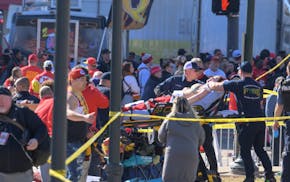 A woman is taken to an ambulance after an incident following the Kansa City Chiefs NFL football Super Bowl celebration in Kansas City, Mo., Wednesday,