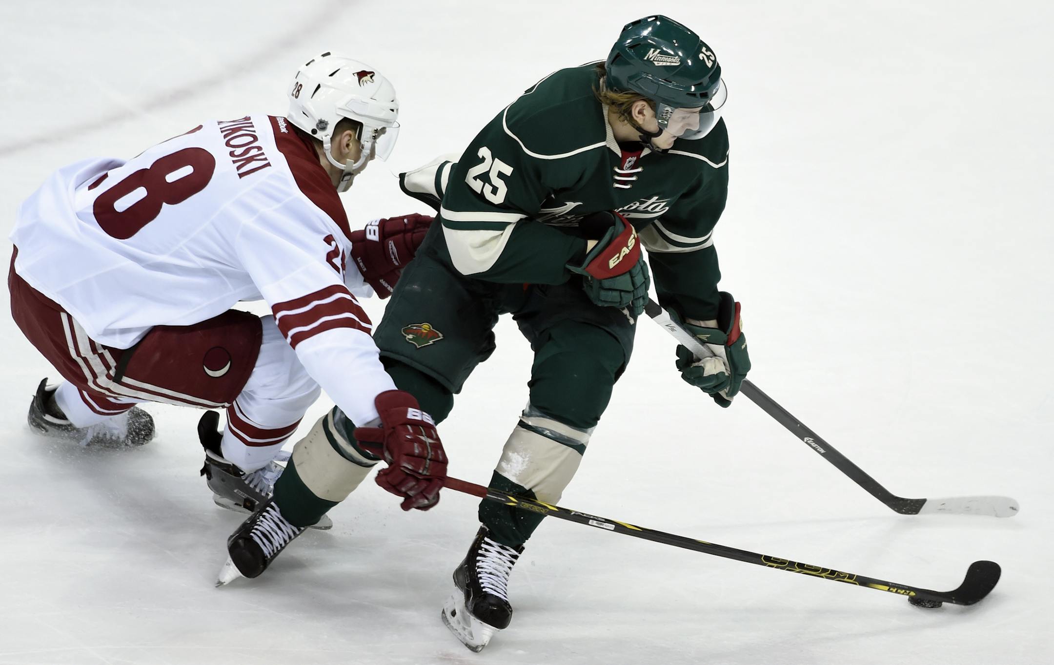 Arizona Coyotes left wing Lauri Korpikoski (28), of Finland, reaches for the puck controlled by Minnesota Wild defenseman Jonas Brodin (25) during the first period of an NHL hockey game Saturday, Jan. 17, 2015, in St. Paul, Minn. (AP Photo/Hannah Foslien)