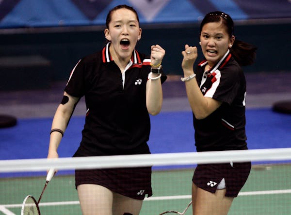 Eva Lee, left, and Paula Obanana celebrate during a badminton women's doubles semifinal match in 2011.