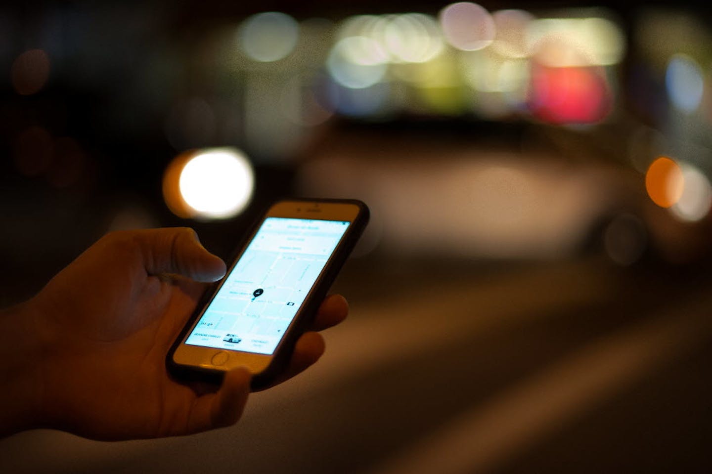 An Uber customer checked on the status of his ride on his phone while waiting at Lagoon and Hennepin avenues in Minneapolis late on a Saturday night in August.