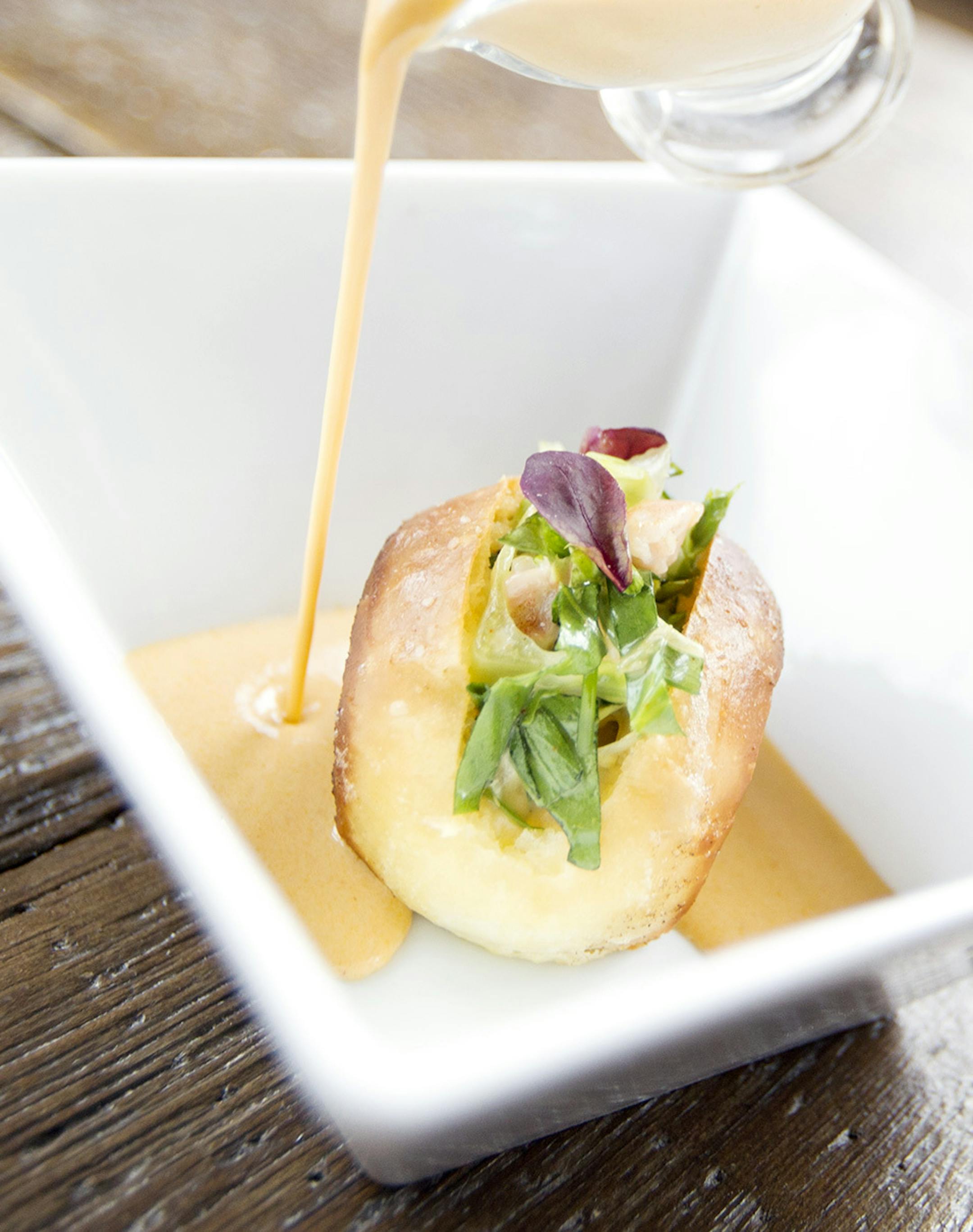 Lobster bisque poured on a toasted brioche lobster roll with shrimp, parsley, chive, tarragon, and chervil at Travail and the Rookery in Robbinsdale April 18, 2014. (Courtney Perry/Special to the Star Tribune)