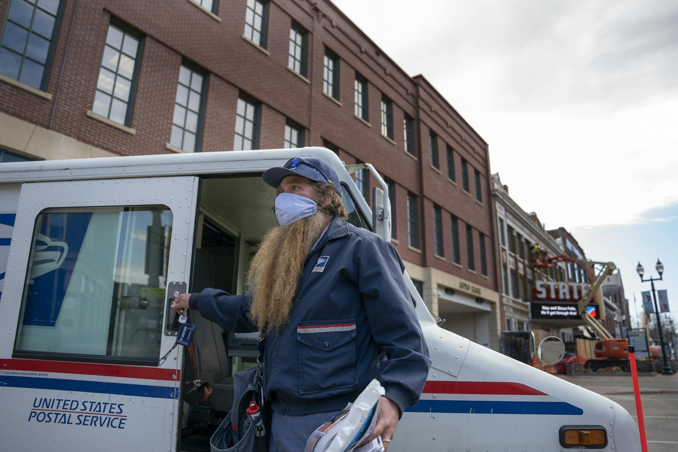 Don Shea wearing a mask ,delivered the mail Phillips street in downtown Sioux Falls.