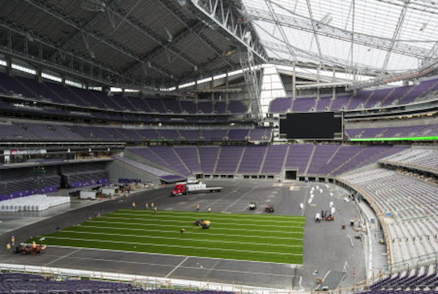 Workers lay down artificial turf at US Bank Stadium in May 2016.