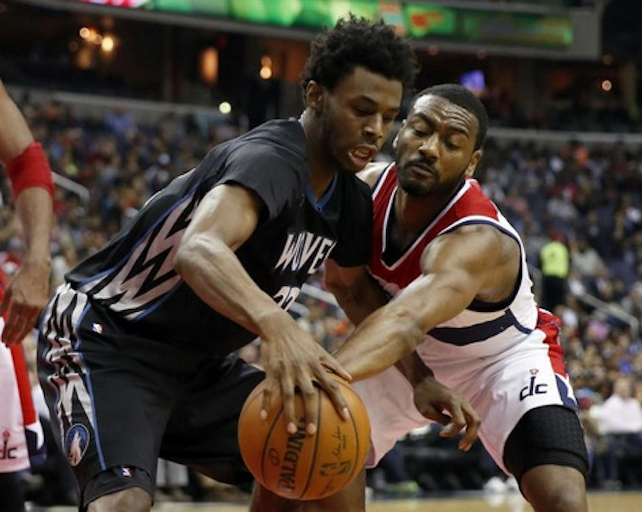 Minnesota Timberwolves guard Andrew Wiggins (22) tries to keep the ball from Washington Wizards guard John Wall during the first half of an NBA basketball game Friday, March 25, 2016, in Washington.