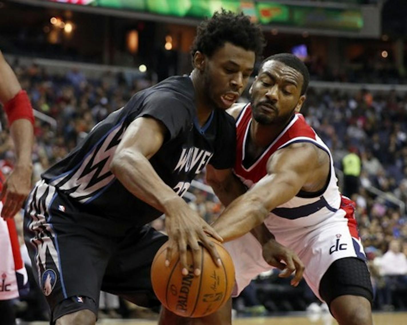 Minnesota Timberwolves guard Andrew Wiggins (22) tries to keep the ball from Washington Wizards guard John Wall during the first half of an NBA basketball game Friday, March 25, 2016, in Washington.