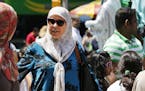 Muslim women walk past Statue of Liberty characters, Sunday, July 17, 2016, in New York's Times Square. (AP Photo/Mark Lennihan) ORG XMIT: OTKNYML106