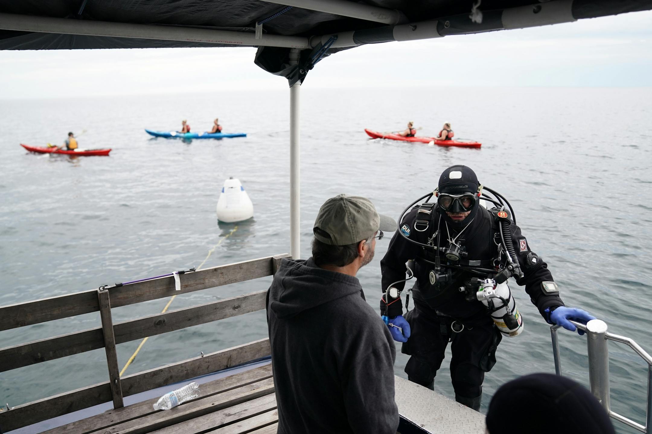 Corey Daniel, right, a diver with the Great Lakes Shipwreck Preservation Society from Duluth, talked with fellow diver Jim Christenson as a group of kayakers passed by as Daniel prepared to dive the Madeira shipwreck near Split Rock Lighthouse.