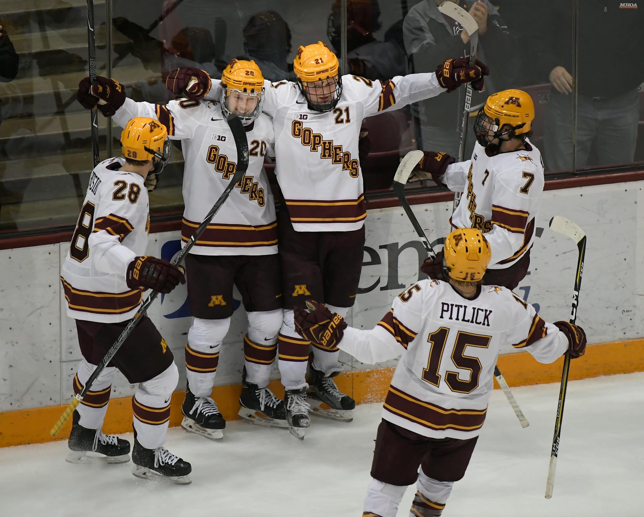 Teammates celebrated with Gophers forward Casey Mittelstadt (21) after Mittelstadt scored a goal in the second period against Harvard