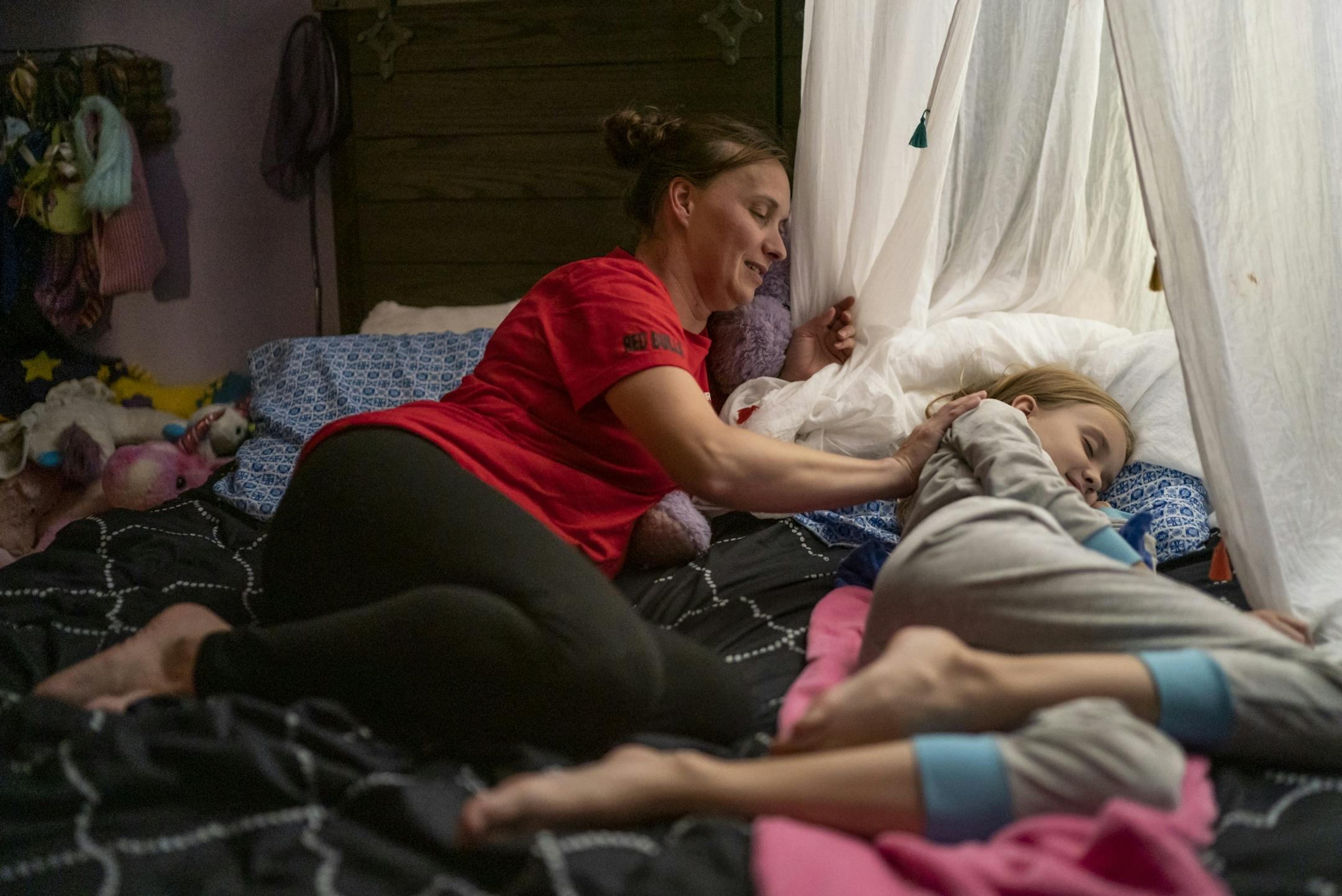 Jeanette Chafee rubbed her daughter Madison's, 8, back as she put her to sleep at home in Scandia, Minn., on Wednesday, September 18, 2019. Bedtime will be one of the biggest adjustments for her girls while she deploys since she puts them to bed most nights.