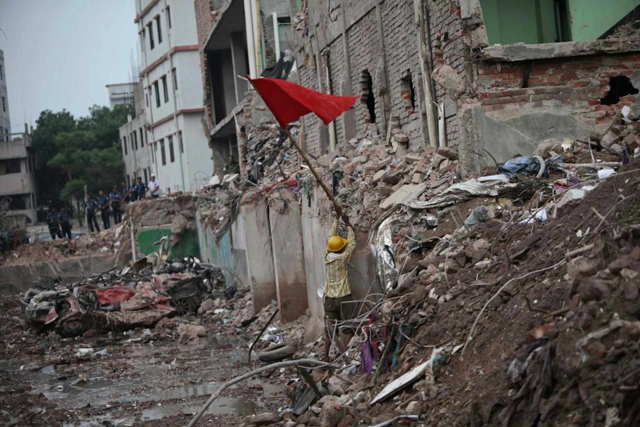 A Bangladeshi rescue worker puts a red flag, marking the end of rescue operations at the site where a Bangladesh garment-factory building collapsed on April 24 in Savar, near Dhaka, Bangladesh, Monday, May 13, 2013. Nearly three weeks after the building collapsed, the search for the dead ended Monday at the site of the worst disaster in the history of the global garment industry.