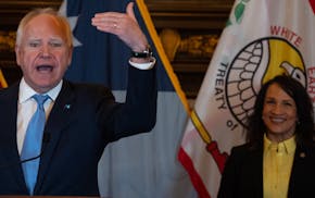 Gov. Tim Walz speaks as House Speaker Lisa Demuth, right, looks on during a press conference in the governor's reception room with all caucus leaders