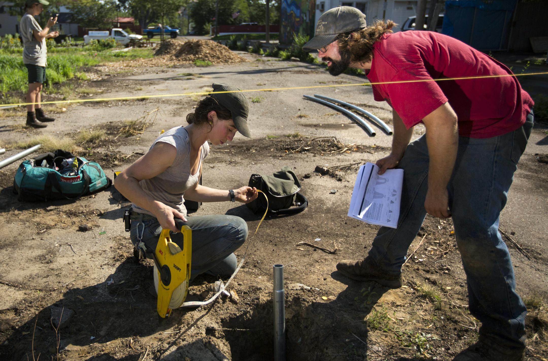 Robin Major, center, and Eric Larsen sized up Not all farms are in the country. Stones Throw Urban farm has converted 14 vacant lots in Minneapolis and St. Paul into mini-farms during the past four years, and recently was certified as an organic farm - apparently the first urban farm in the state to achieve that status. Here, Robin Major (center) and Eric Larsen size up the footings for a high tunnel they are building on the Stones Throw Urban farm on Dale Street in St. Paul. ] St. Paul, MN - 9/