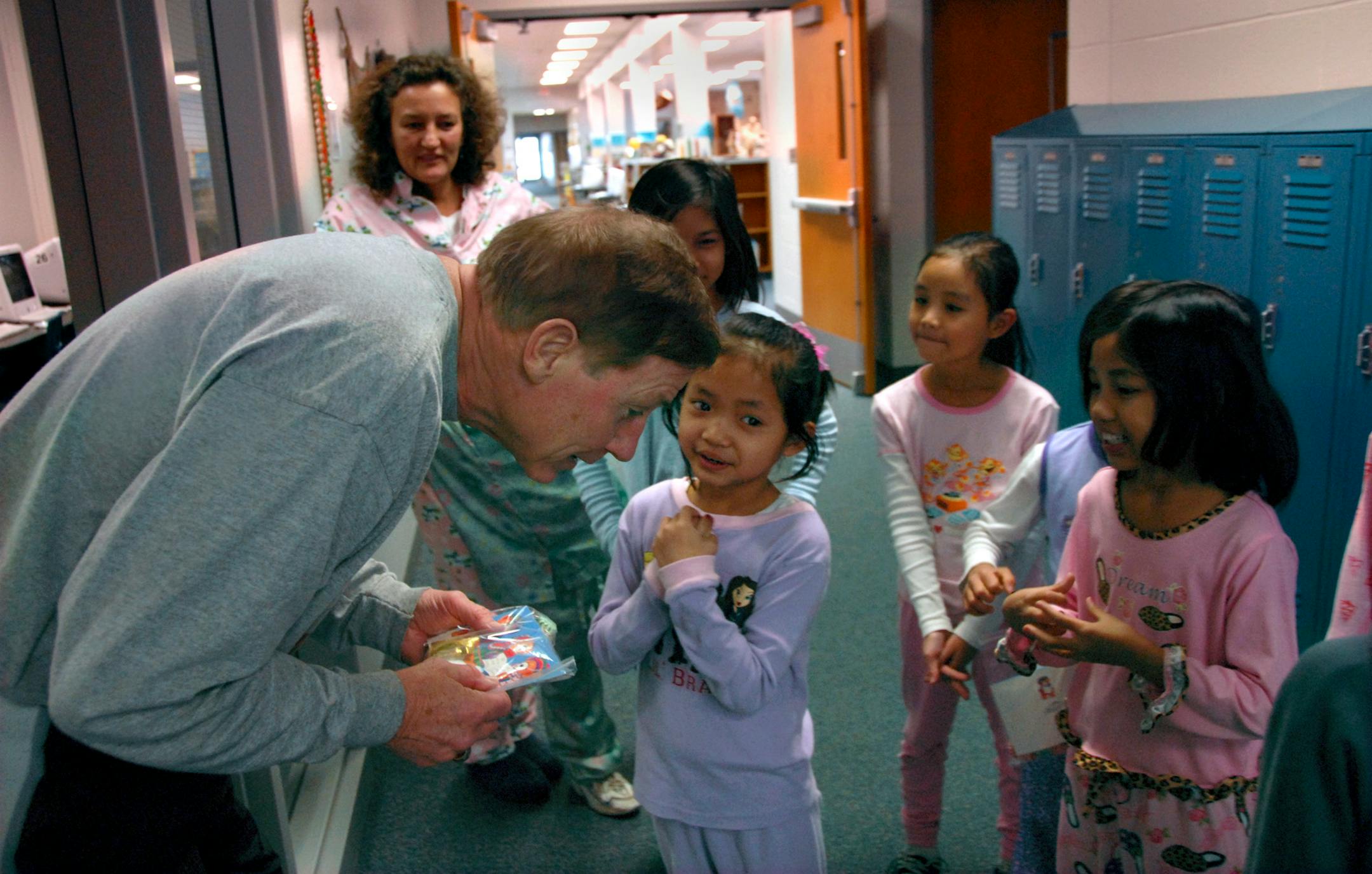 Edgerton Elementary School Principal John Ahern listened as Eh Dah Gyi offered holiday greetings on behalf of the English language learner students. The students in Nenette Onstad's class wrote holiday cards thanking staff members and delivered them with bags of candy. The students are Karen refugees from Myanmar.