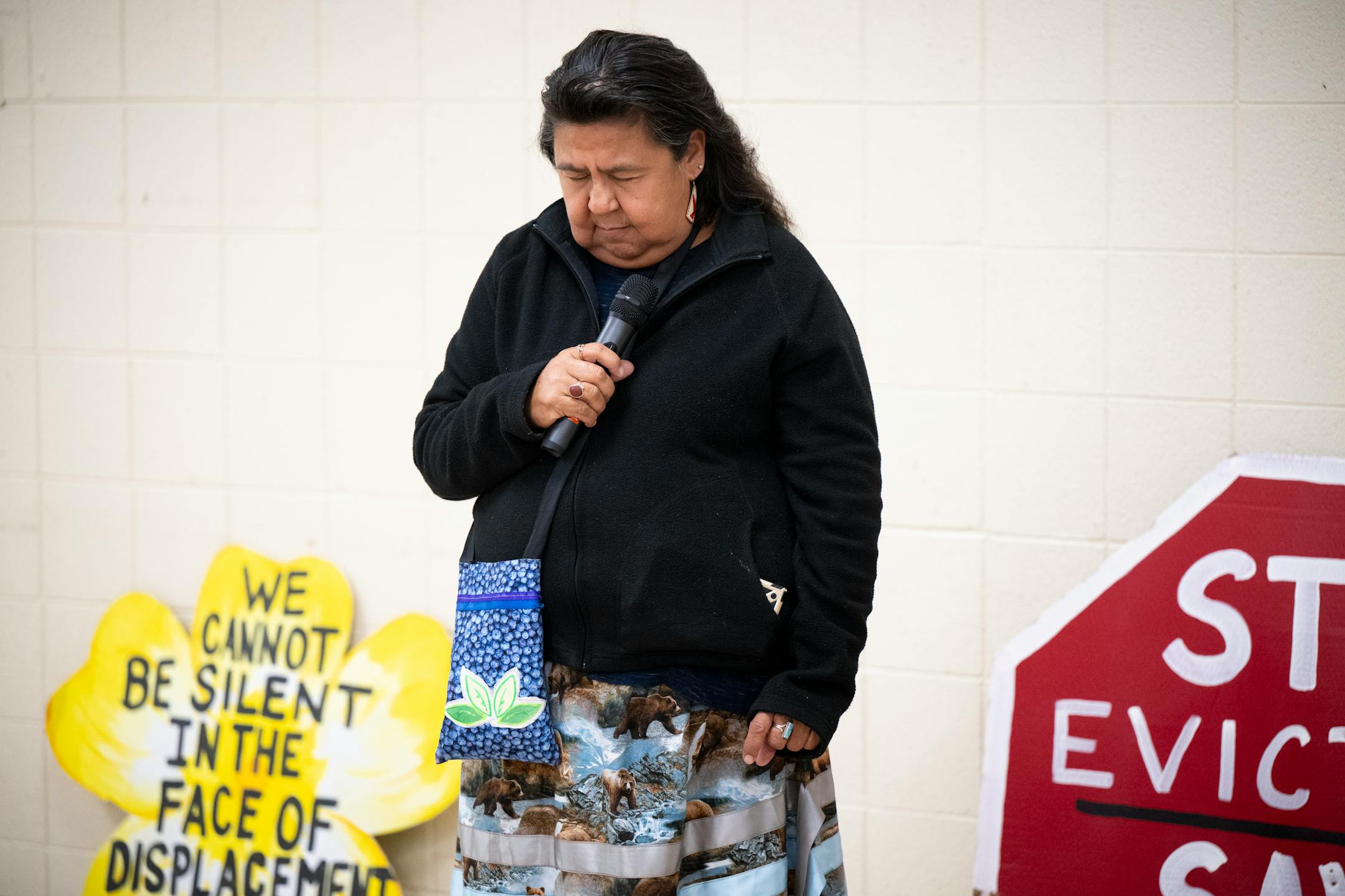 Lisa Bellinger, an official with the American Indian Movement, bows her head in respect to indigenous people and community members who've died in camps over the last 200 years.