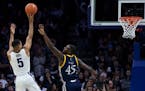 Villanova's Phil Booth, left, shoots over Quinnipiac's Kevin Marfo during the second half of an NCAA college basketball game Saturday, Nov. 10, 2018, 
